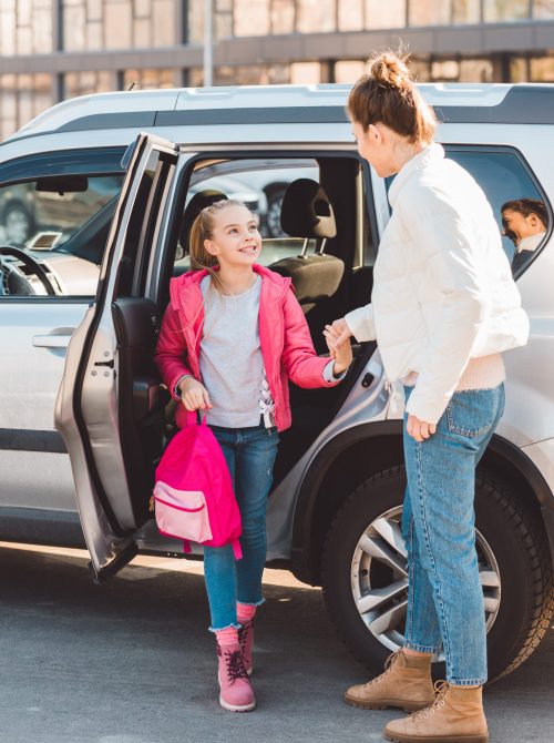 Daughter getting out from car and holding hand of driver. McKinney-Vento transportation